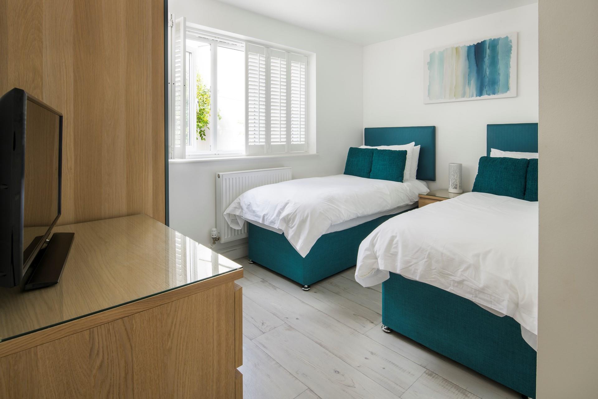 Hues of blue create a luxurious and relaxing feel in bedroom 2. 