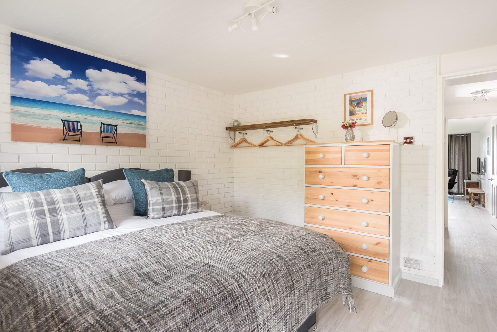 You enter into the comfortable bedroom, with white-washed walls and open clothes hanging space, handmade from local driftwood. 