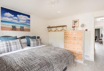 You enter into the comfortable bedroom, with white-washed walls and open clothes hanging space, handmade from local driftwood. 