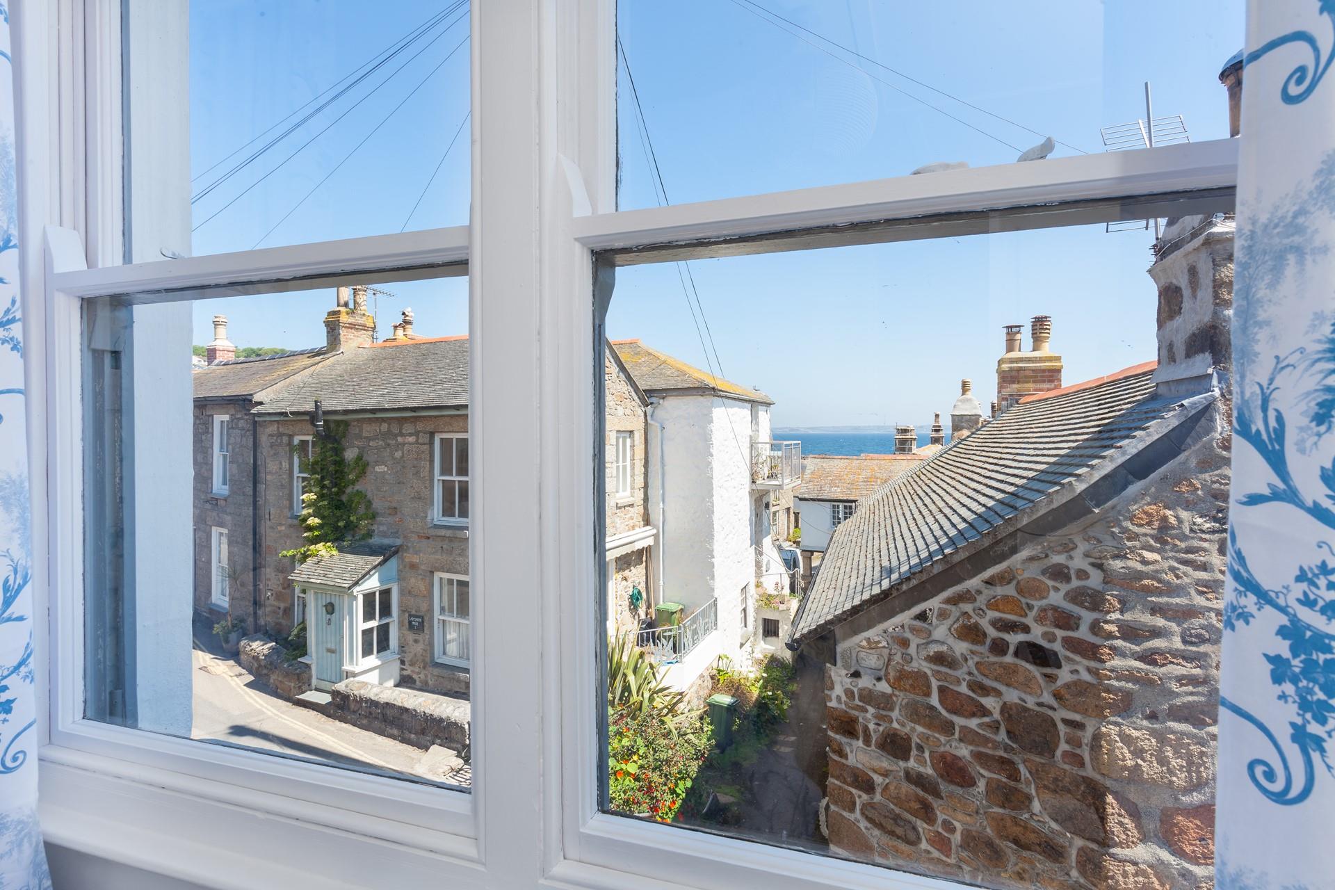 The view from the master bedroom looks through rooftops and over Mounts Bay towards the Lizard Peninsular.