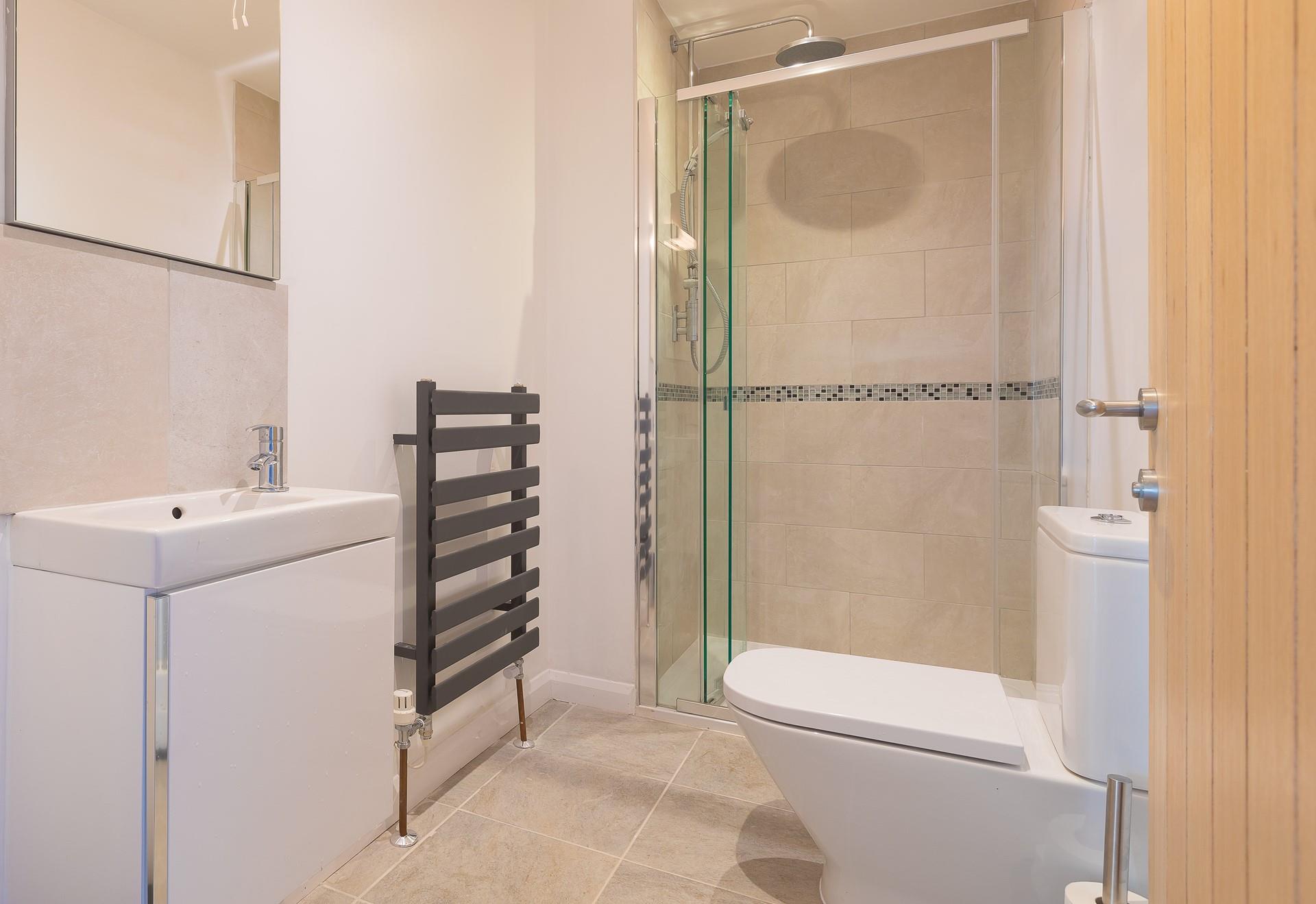 Modern and spacious, the ensuite shower room features a large rainfall showerhead, perfect for a refreshing morning shower. 
