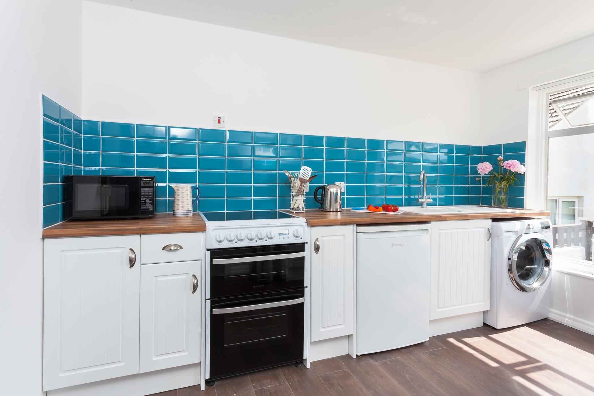 The spacious kitchen with bright tiles and modern appliances has everything you need to whip up delicious meals!