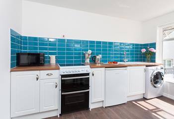 The spacious kitchen with bright tiles and modern appliances has everything you need to whip up delicious meals!