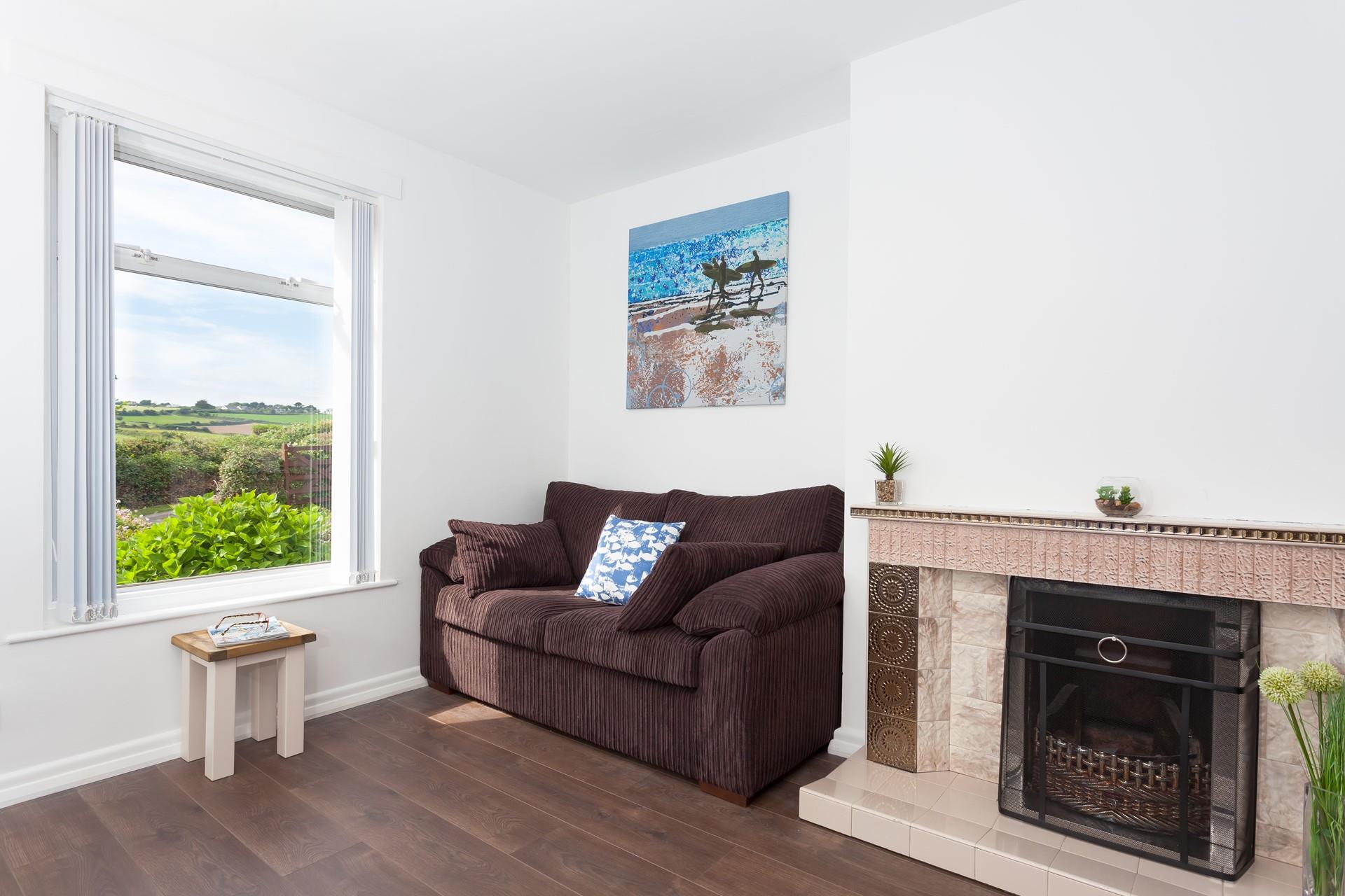 The two-seater sofa is situated in the sun trap by the window, creating the perfect space to relax with a good book.