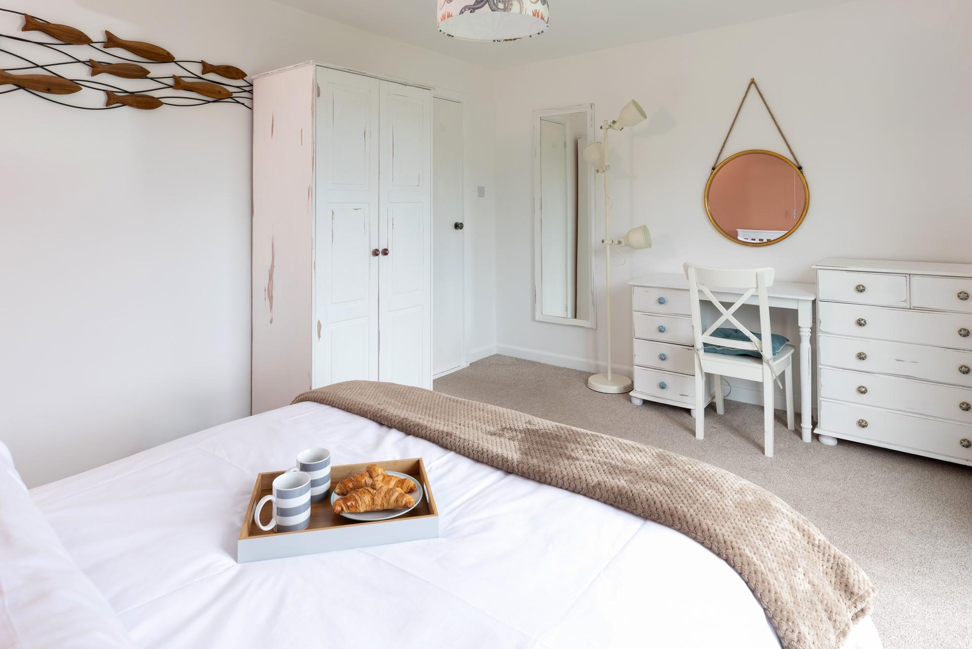 Wooden drawers, bedside tables and a large wardrobe ensure that guests have ample space for their belongings.