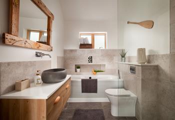 The modern and stylish bathroom has a walk-in shower and an indulgent bathtub.