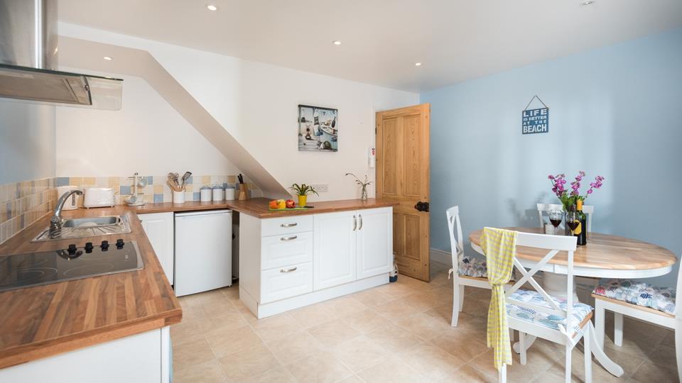 Coastal blues and whites, paired with wooden worktops have created an inviting kitchen and dining area. 