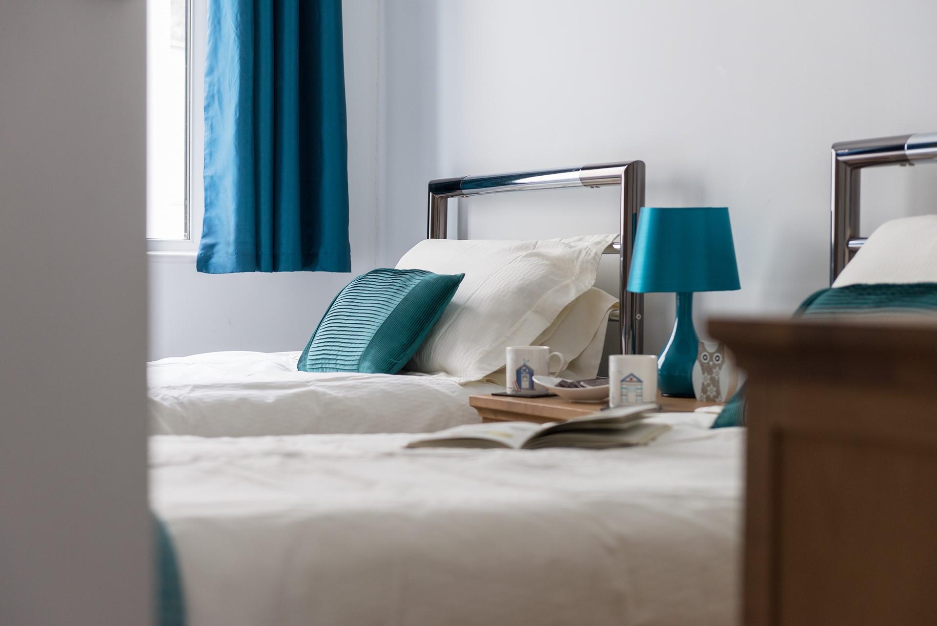 Cosy twin beds with modern decor make this bedroom perfect for children and teenagers.