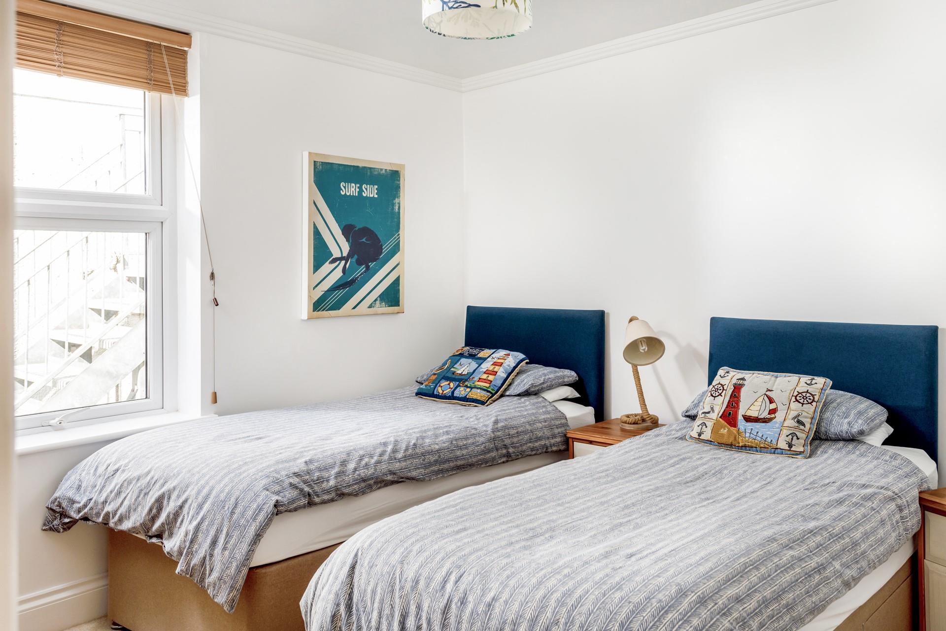 The twin beds are perfect for adults or children and have a seaside theme.