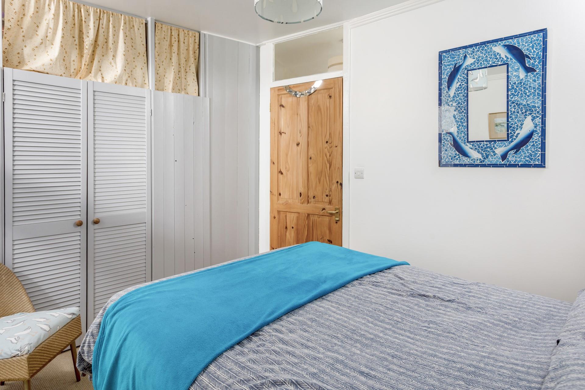 The double bedroom has built-in louvre wardrobes with further storage above.