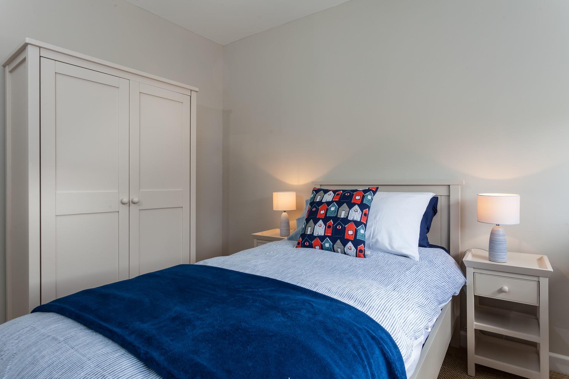 Bedroom 4 has a single bed and is decorated in a blue beachside theme.