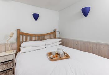 Crisp sheets and a calming colour palette welcome you into the bedroom.