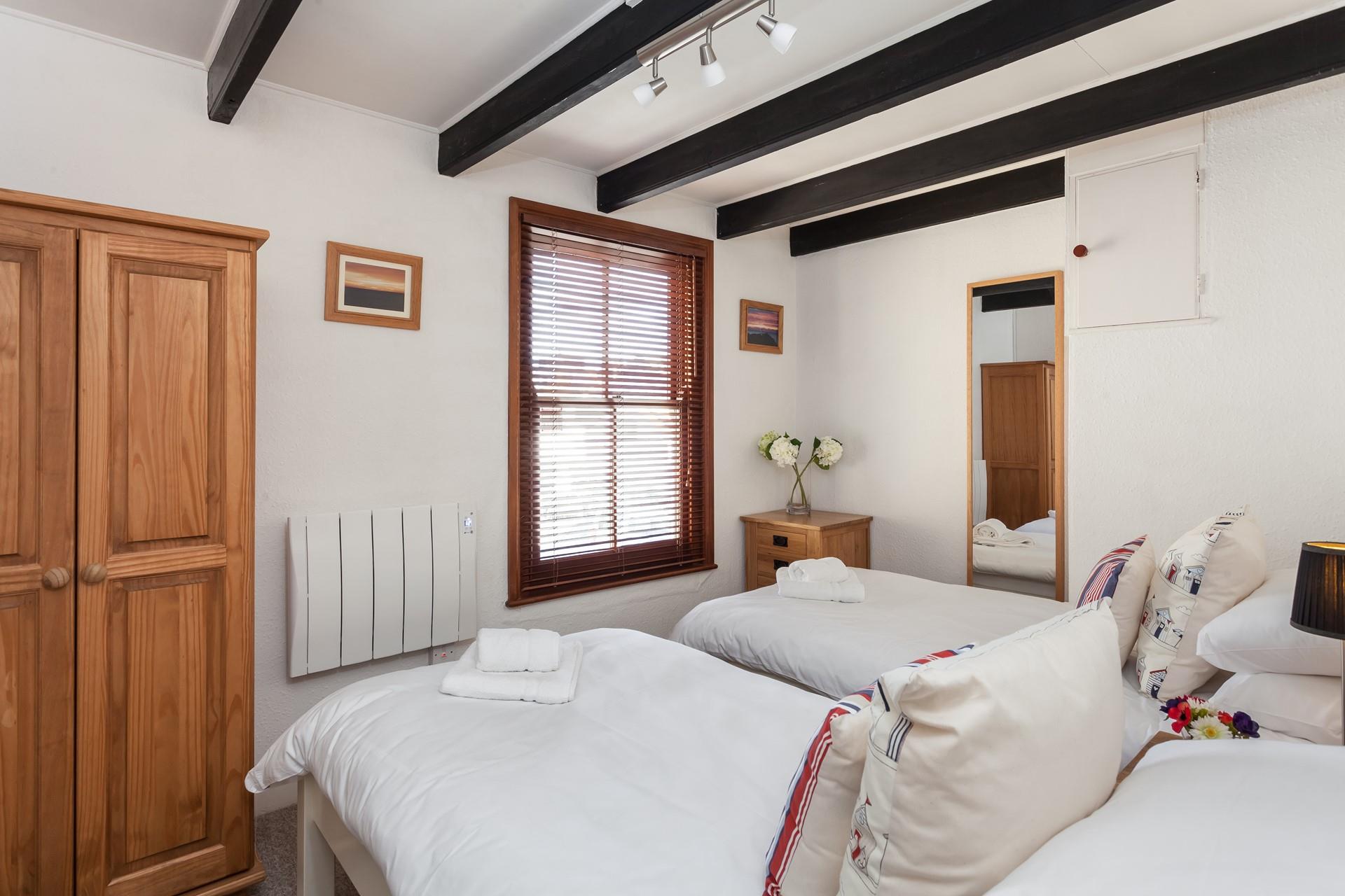 Exposed beams in the twin room exude an enchanting cottage feeling. 