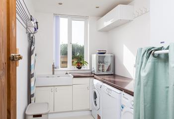 A downstairs utility room offers a convenient space to pop clothes in the wash after a day out.