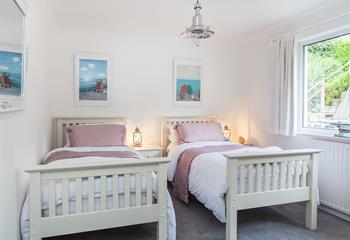 Sweet wooden twin beds mixed with muted shades and charming artwork have created a haven of relaxation that is perfect for adults and children alike.
