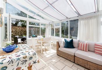 Large conservatory with comfortable seating, perfect for relaxing with a bottle of wine.