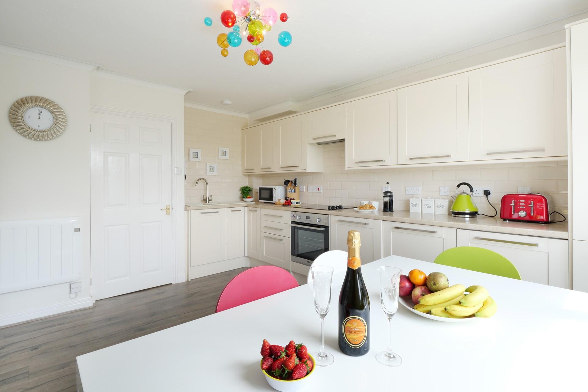 The bright and contemporary kitchen is fully equipped for your stay. We love the colourful light shade, chairs, and appliances!