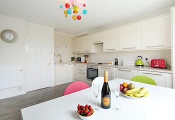 The bright and contemporary kitchen is fully equipped for your stay. We love the colourful light shade, chairs, and appliances!