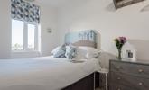 Bedroom 1 has views of the beach that inspired the seaside decor. - Thumbnail Image