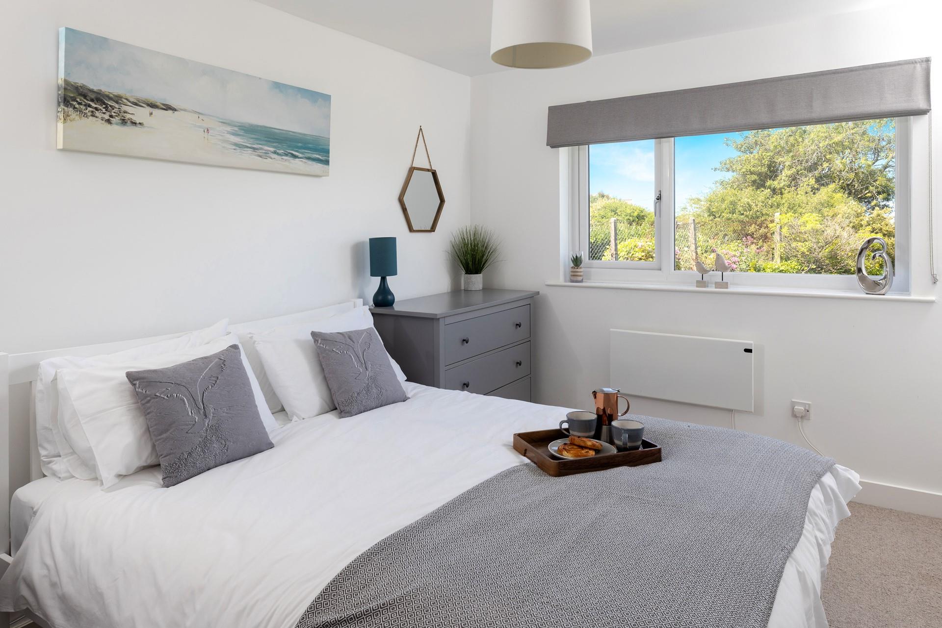 Tones of grey and fresh whites create a calming environment in bedroom 1.