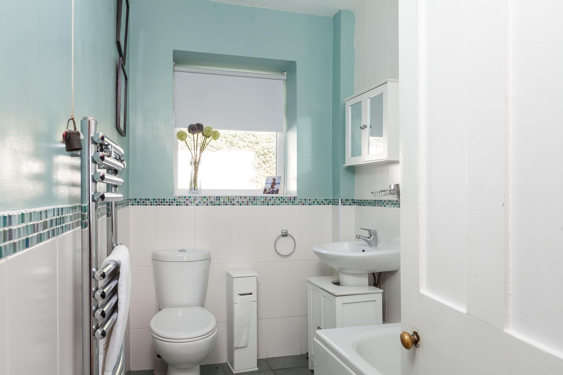 The bathroom is a fresh, bright space, perfect for an invigorating shower after a morning stroll along the beach!