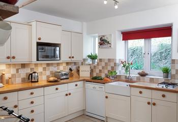 The country cottage-style kitchen is well-equipped with modern appliances making it an absolute joy to cook in!