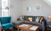 The sitting room has a contemporary style with sea views across the rooftops. - Thumbnail Image