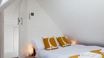 Bedroom 3 is comfortable and decorated with a pop of colour.