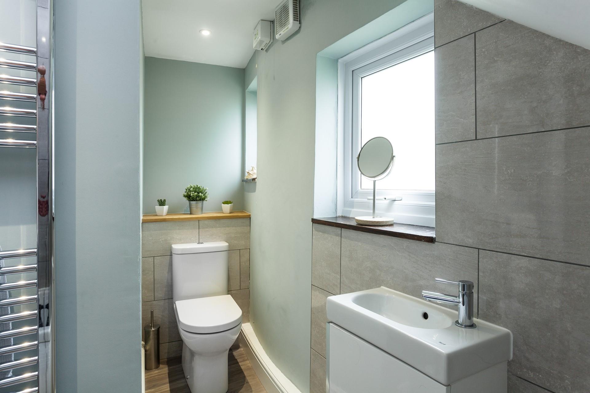 In the modern family bathroom there features grey stone effect wall tilling.