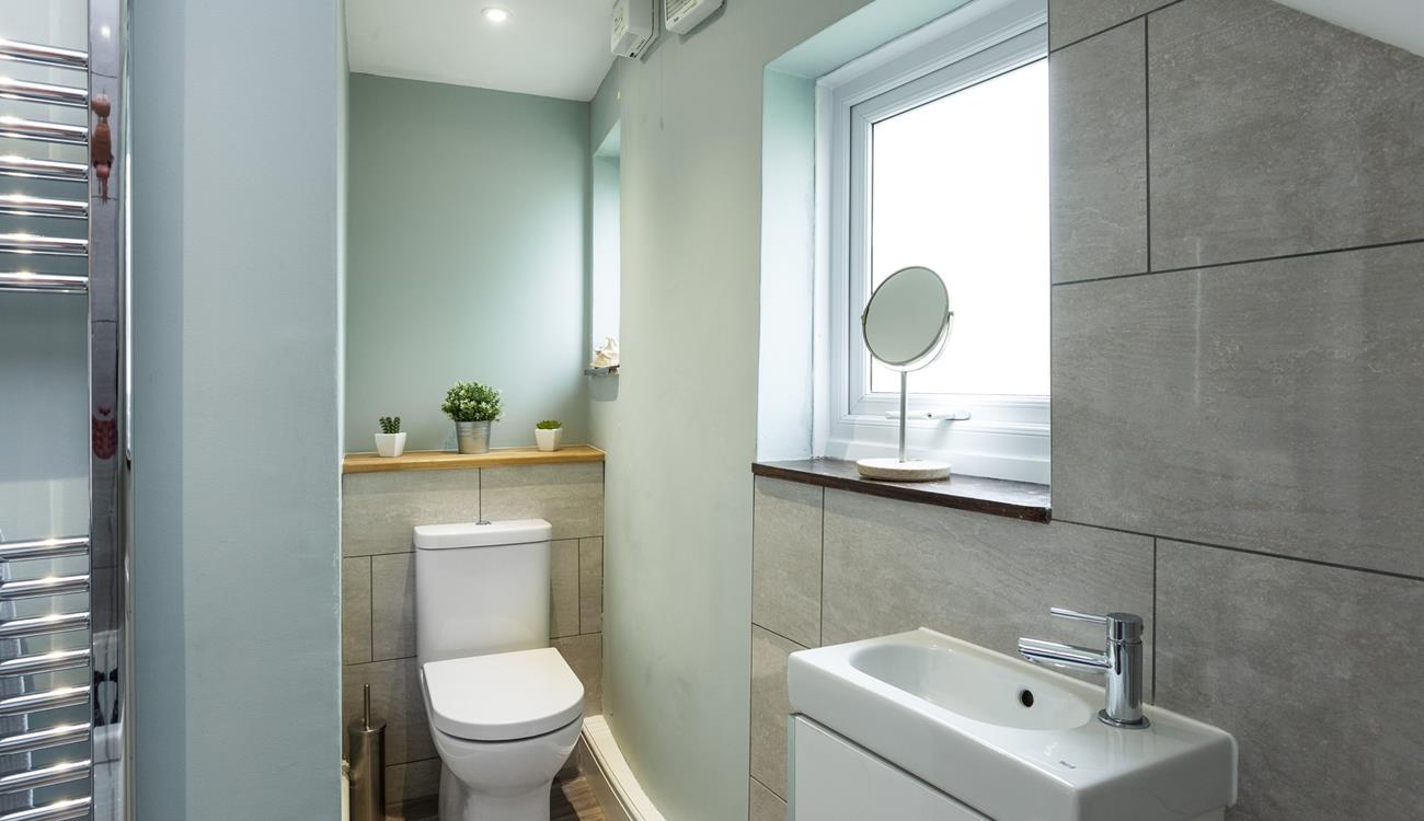In the modern family bathroom there features grey stone effect wall tilling.