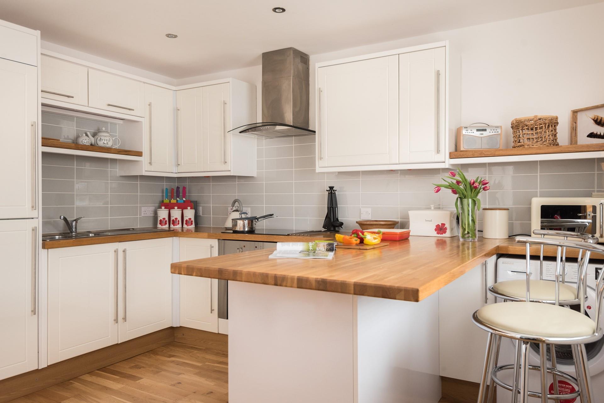 The well-equipped kitchen with breakfast bar is the perfect place for reading a paper in the morning.
