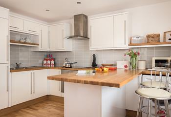 The well-equipped kitchen with breakfast bar is the perfect place for reading a paper in the morning.