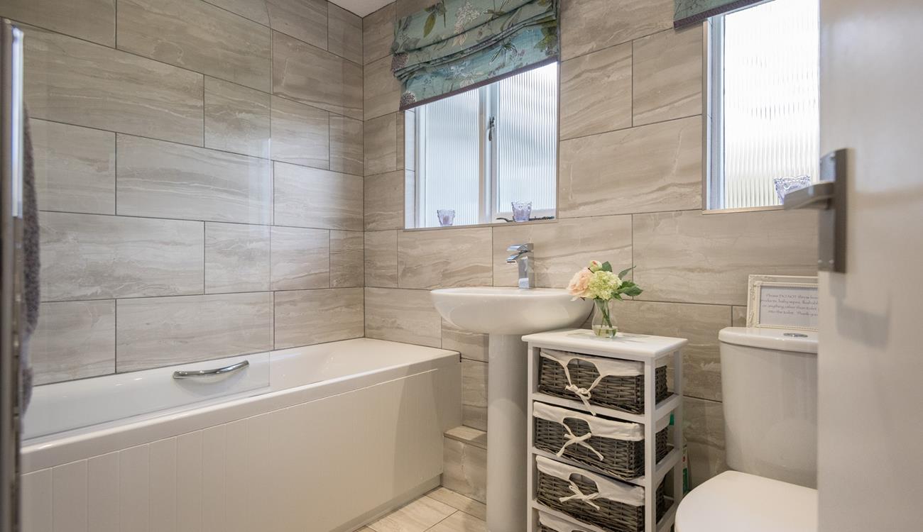 The bathroom is modern and sleek, ideal for running a hot bath and pampering yourself.
