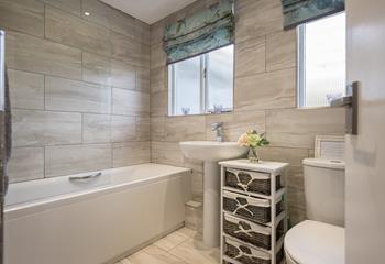 The bathroom is modern and sleek, ideal for running a hot bath and pampering yourself.