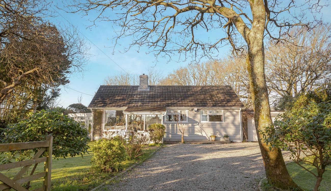 Enter up the gravel driveway and be greeted with a tranquil leafy garden.
