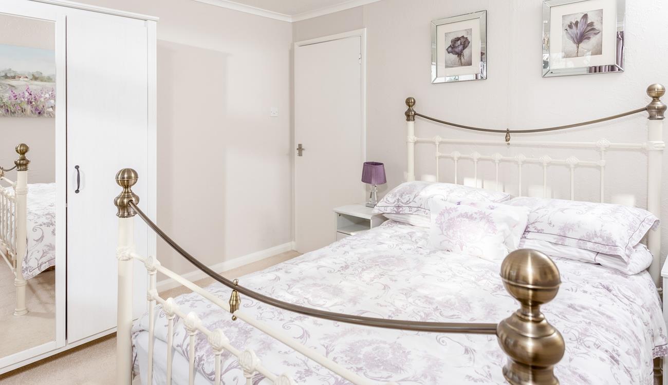 Pretty purples and prints make this bedroom another cosy space for enjoying a lazy lie in. 