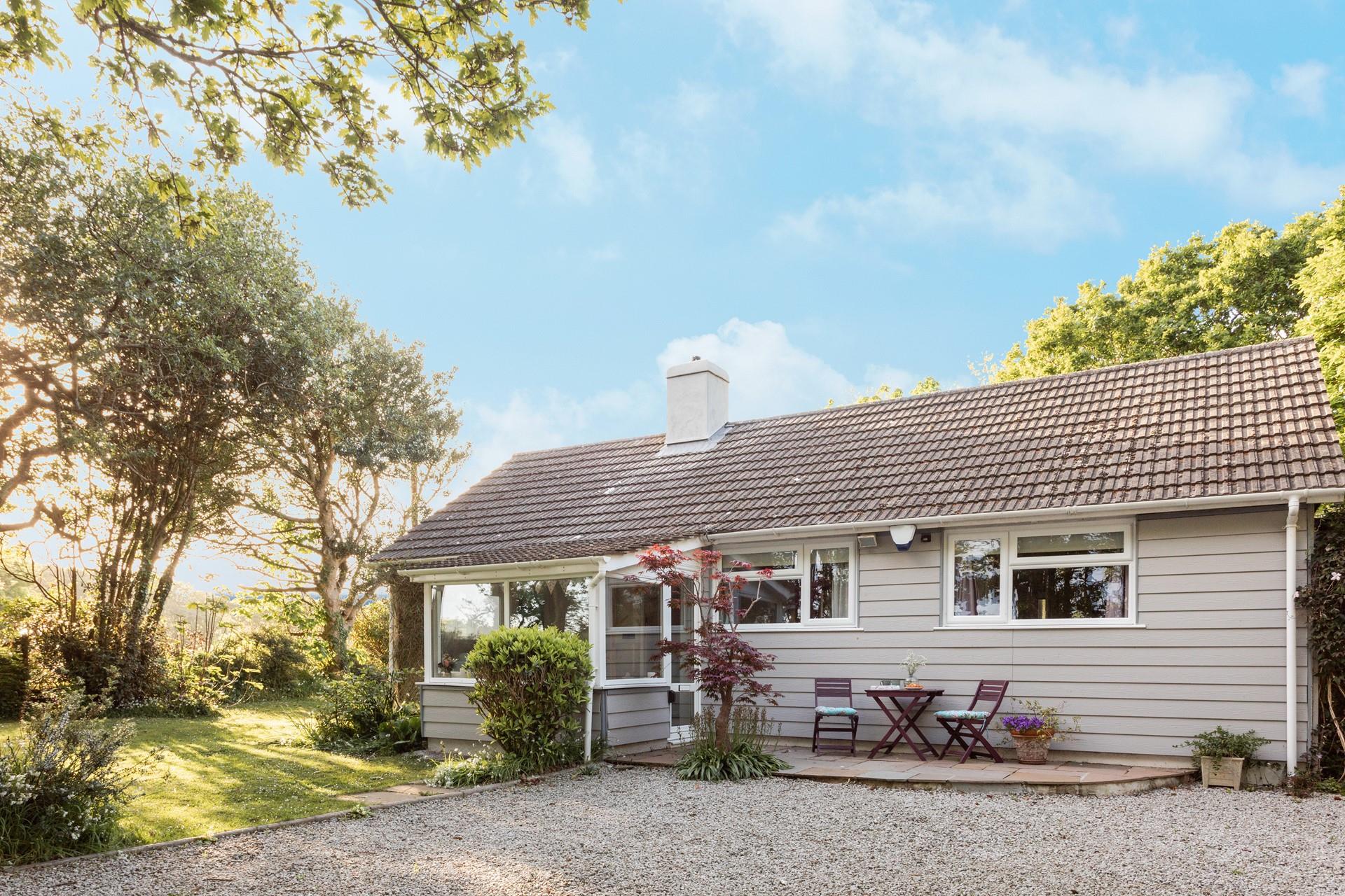 The gravel drive with a gate has parking for two cars, offering both privacy and security.