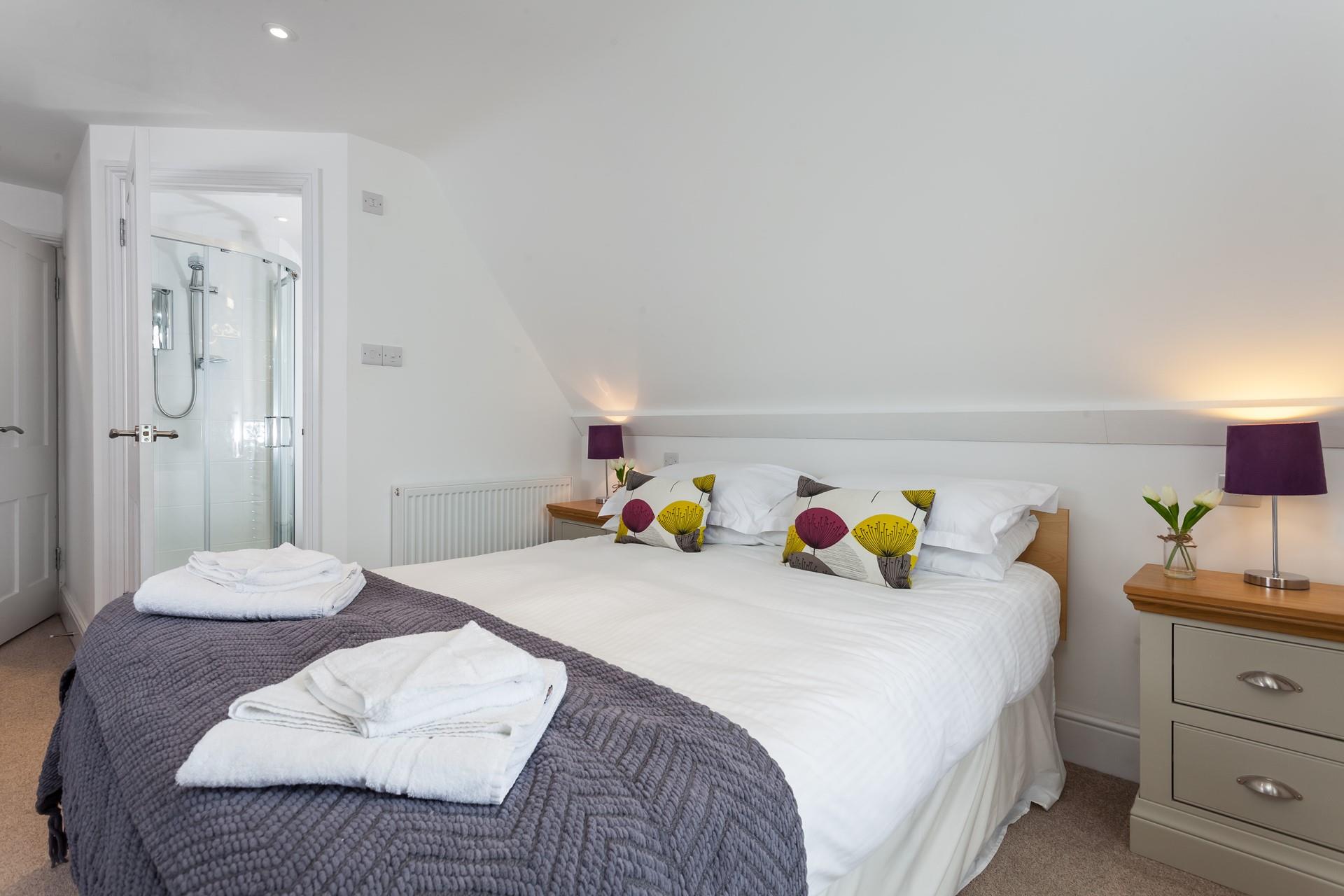 Bedroom 2 has an ensuite and is decorated with bright pops of colour.