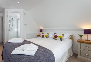 Bedroom 2 has an ensuite and is decorated with bright pops of colour.