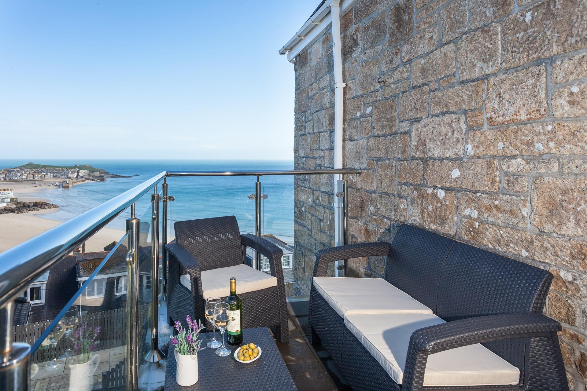 Sit and the beautiful sea view across St Ives Harbour and beach with a glass of wine.