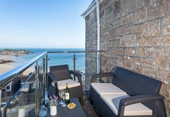 Sit and the beautiful sea view across St Ives Harbour and beach with a glass of wine.