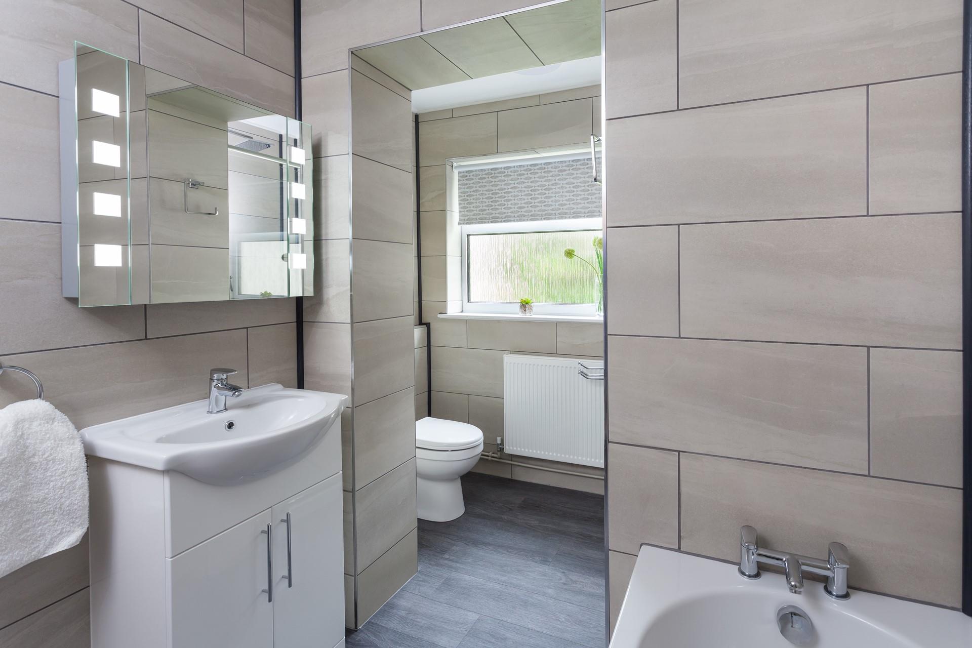 The bathroom is modern with a luxury, spa-like feel, perfect for having a relaxing bath at the end of the day.