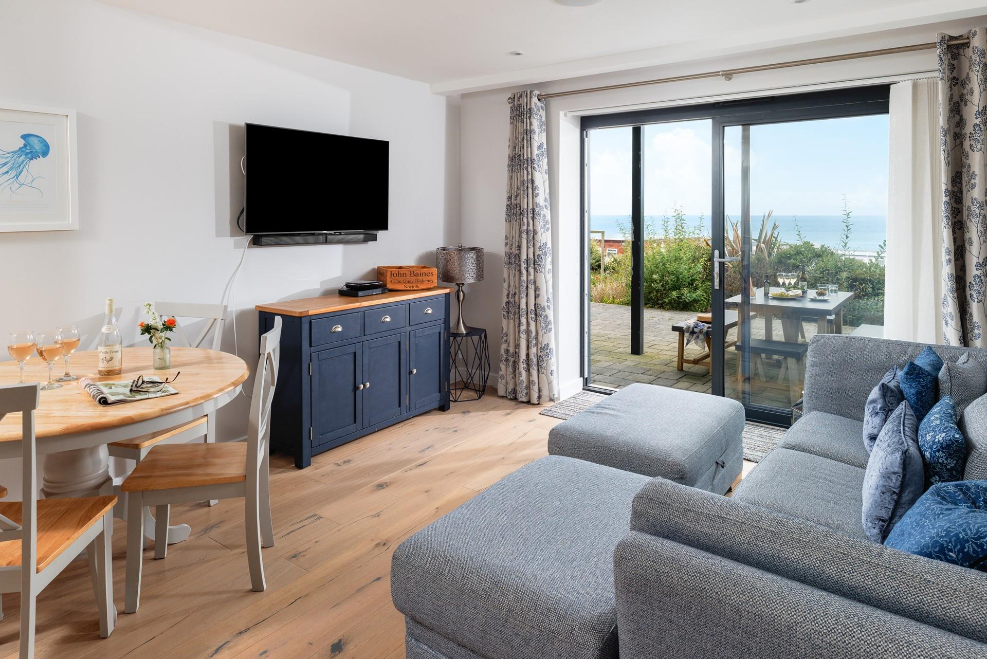 The comfortable sofa and the nautical-themed decor make the living area a relaxing space for cosying up in the evening.