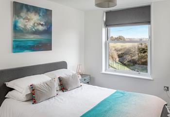 Stylishly designed bedroom 1 has calming colours and views over the golf course to wake up to each day.