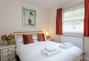 The matching accent cushions and curtains set a really lovely tone in this comfortable bedroom, with a double bed.