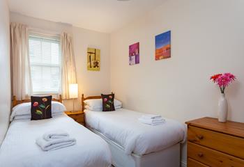 Bedroom two benefits from twin beds, perfect for young adults or teenagers wanting their own space.