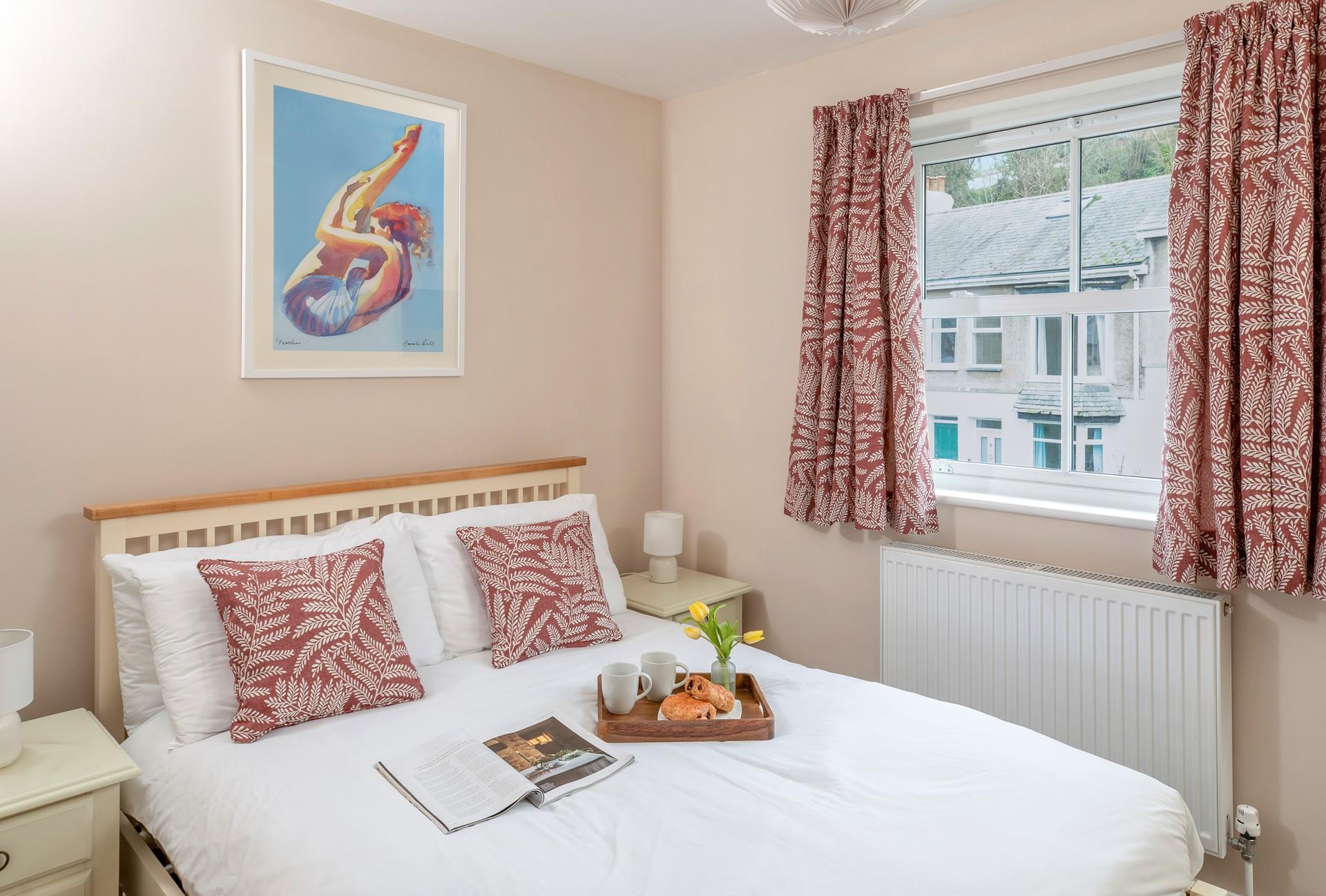 Co-ordinating cushions and curtains create a homely feel in the comfortable double bedroom.