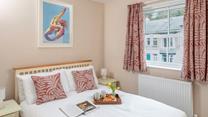 Co-ordinating cushions and curtains create a homely feel in the comfortable double bedroom.