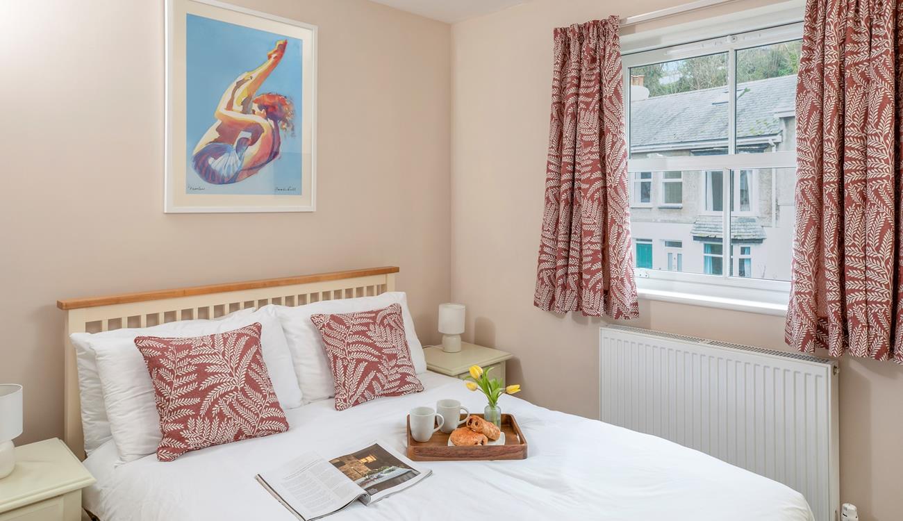 Co-ordinating cushions and curtains create a homely feel in the comfortable double bedroom.