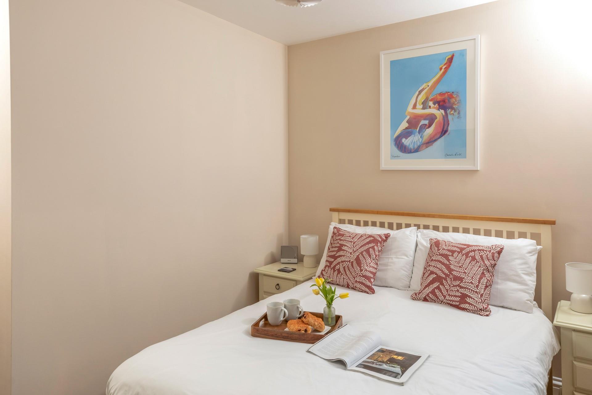 Bright artwork adorns the double bedroom wall.